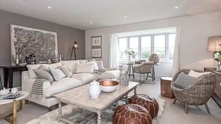 Modern neutral living room with sofa, coffee table overlooking the window, stylish gray walls and abstract wall art