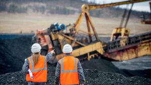 construction workers point fingers at nearby mining equipment